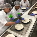 Employees hand-finish cheesecakes on the production line at Eli's in Chicago.